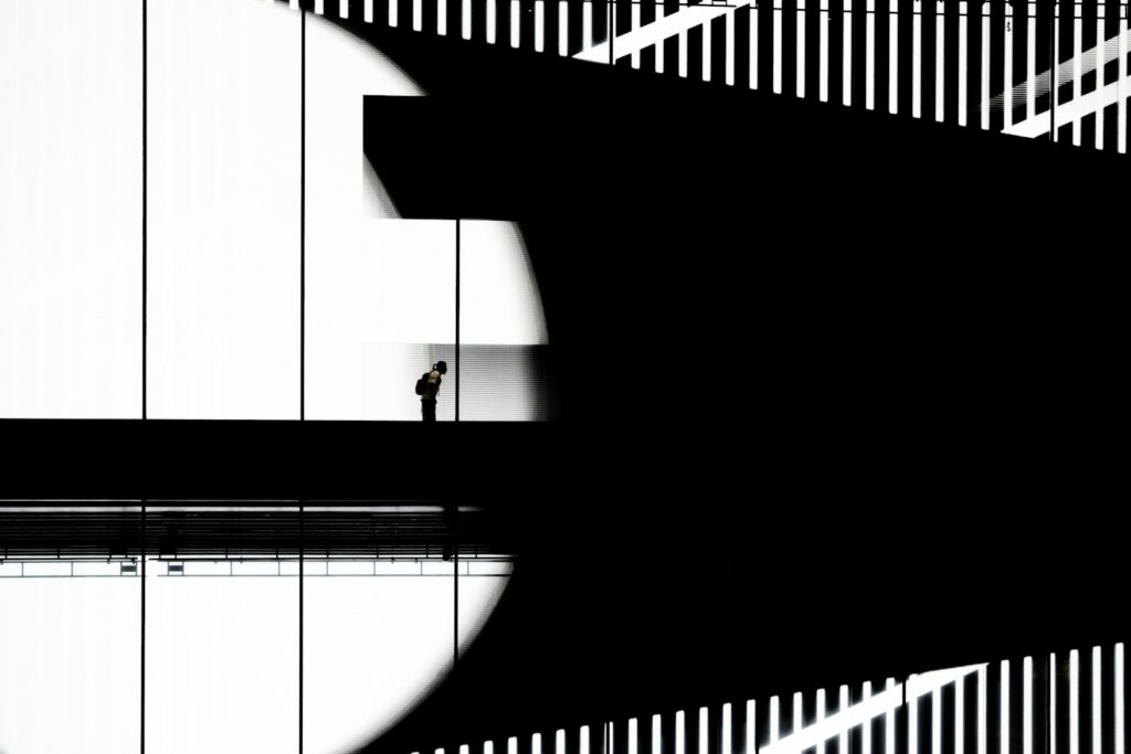 Man standing on walkway with abstract shadows