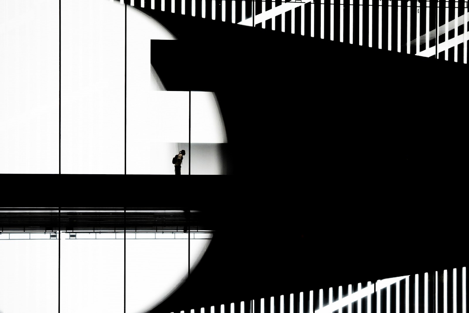 Man standing on walkway with abstract shadows